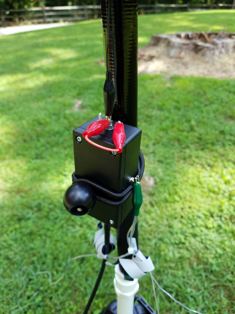 The matching network is attached to the pole with a small bungee cord. In this picture, the red jumpers are configured for the 30M band.