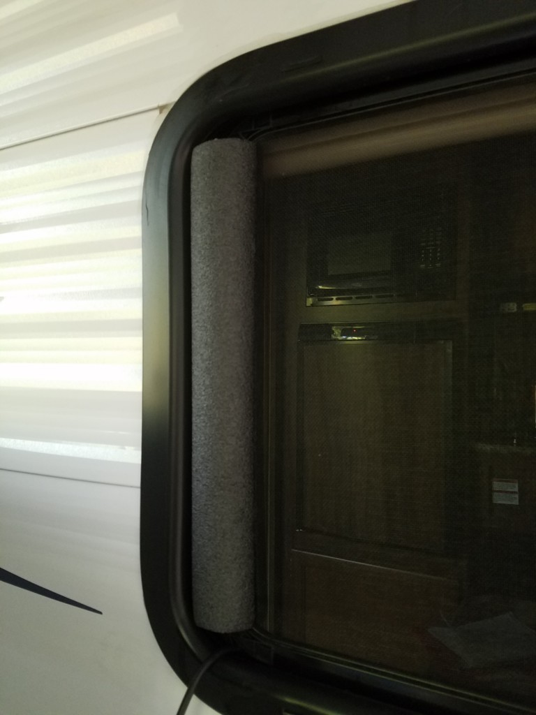 Pipe insulation used to help close the gap in the window. The black pipe insulation is barely noticeable making it XYL-approved.