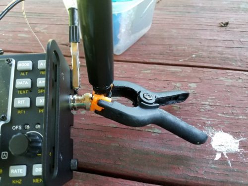 The MFJ-1820T whip connected to my KX3. The plastic spring clamp was used to stabilize the whip. You can also see the alligator clip for the radials.