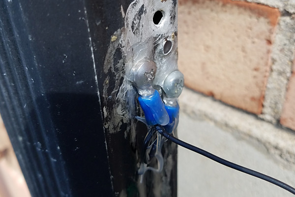 This is the connection to the downspout. Two ring terminals, jumpered together, are used to ensure a good connection. I used a liberal application of Goop sealant to weather-proof the connections. (A second coat was applied after this picture was taken.) You can see some holes from previous connections. (Note to Self: Do some touch up painting on the downspout!)