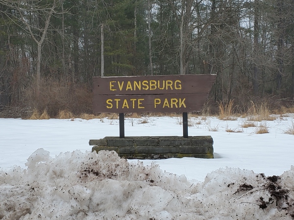 The Evansburg State Park entrance sign with the dirty remnants of last month's snow