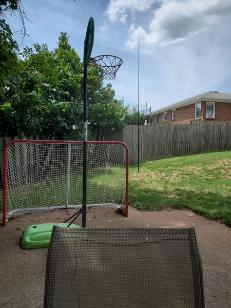 My thrown-together antenna. A 35-foot wire runs from the chair, over the basketball net, and up to the 20-foot pole in the background.